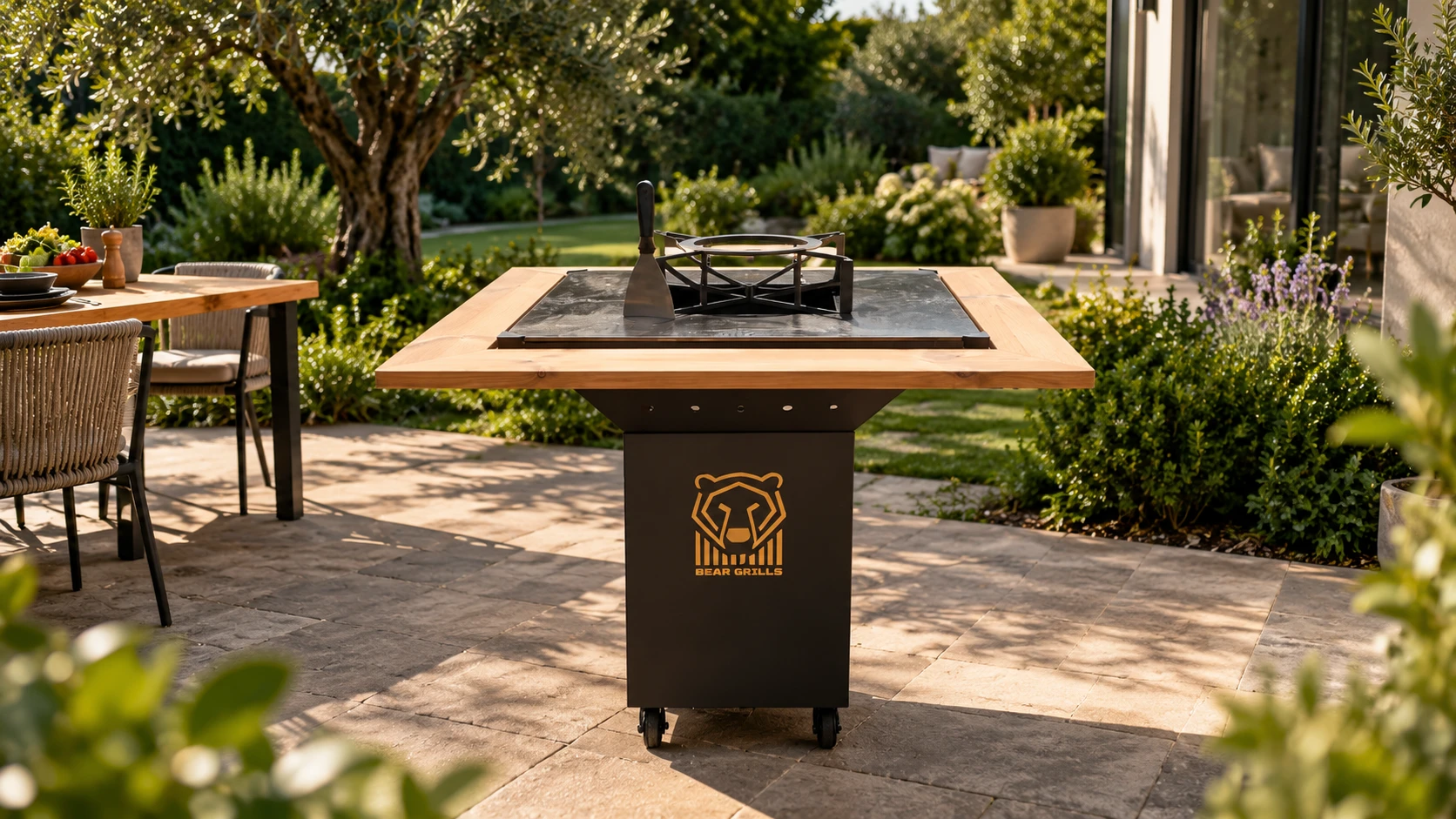 Grătarul Bear Grills pe o terasă, cu blat din lemn și plită din oțel